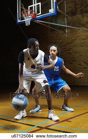 Picture - Basketball players playing on court. Fotosearch