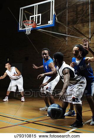 Stock Photography - Basketball players playing on court. Fotosearch