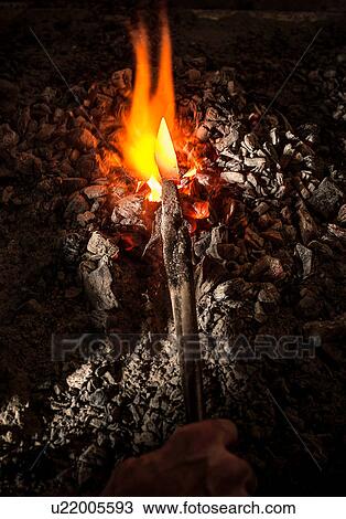 Blacksmith holding metal knife in furnace View Large Photo Image Stock Image - Blacksmith holding metal knife in furnace. Fotosearch