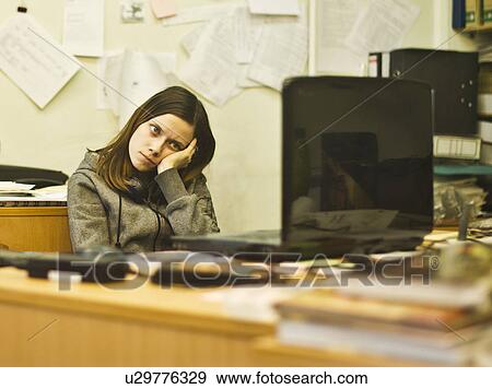 Bored young woman at desk leaning on elbow View Large Photo Image Stock Photo - Bored young woman at desk leaning on elbow. Fotosearch