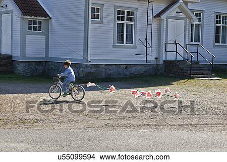 Picture - Boy riding bicycle pulling bunting. Fotosearch