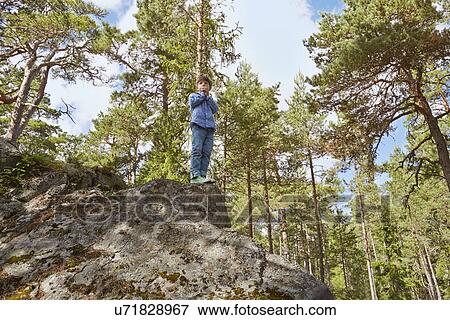 Boy standing on top of rock View Large Photo Image Stock Photo - Boy standing on top of rock. Fotosearch