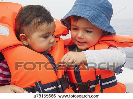 Boy zipping baby's life jacket View Large Photo Image Stock Photograph - Boy zipping baby's life jacket. Fotosearch