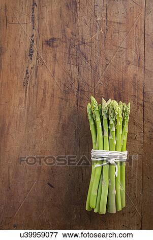 Stock Photo - Bunch of asparagus tied with string, still life. Fotosearch