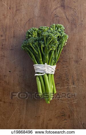 Stock Photograph - Bunch of broccoli tied with string, still life. Fotosearch