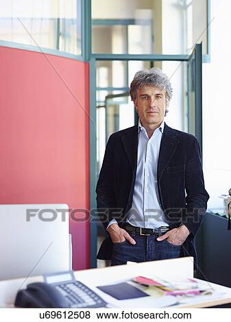 Stock Photo - Businessman wearing suit jacket with hands in pockets. Fotosearch