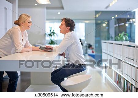 Picture - Businesspeople chatting in office. Fotosearch