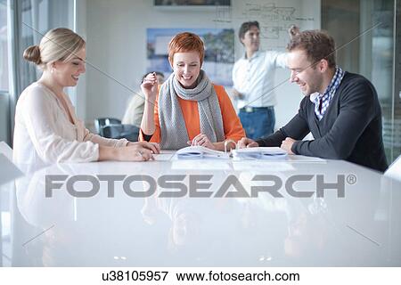 Stock Photo - Businesspeople having meeting at conference table. Fotosearch
