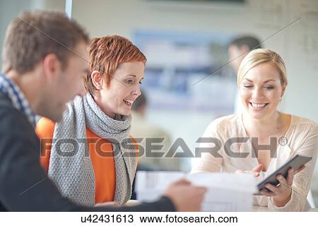 Businesspeople looking at digital tablet View Large Photo Image Stock Image - Businesspeople looking at digital tablet. Fotosearch