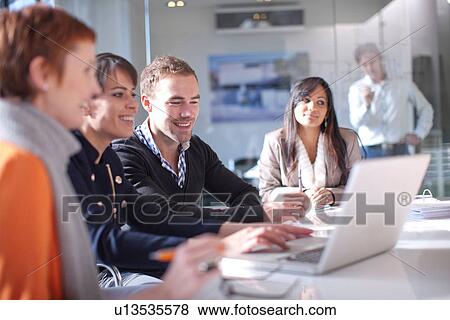 Businesspeople looking at laptop computer, smiling View Large Photo Image Stock Photo - Businesspeople looking at laptop computer, smiling. Fotosearch
