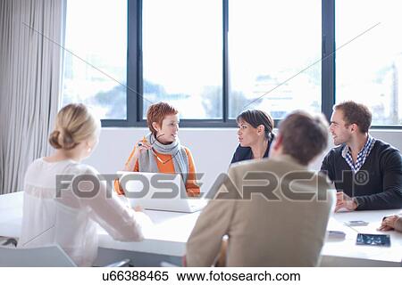 Stock Photography - Businesspeople meeting around conference table. Fotosearch
