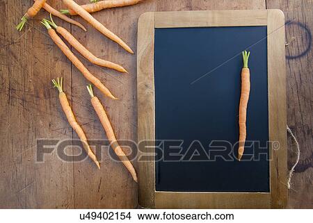 Carrot on blackboard, still life View Large Photo Image Picture - Carrot on blackboard, still life. Fotosearch