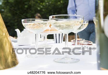 Stock Photograph - Champagne glasses on table, close up. Fotosearch