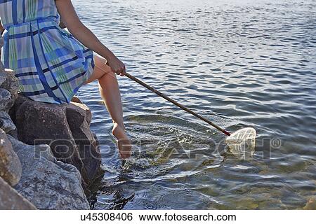 Stock Photograph - Close up of woman with fishing net, Utvalnas, Gavle, Sweden. Fotosearch