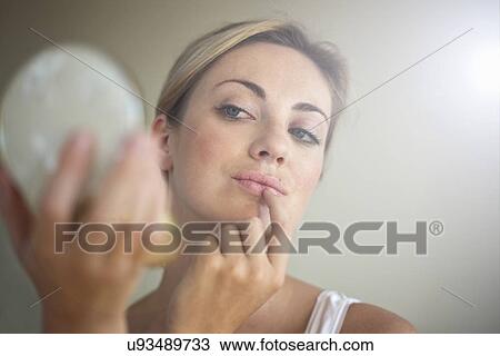Close up of young woman holding compact mirror View Large Photo Image Stock Image - Close up of young woman holding compact mirror. Fotosearch