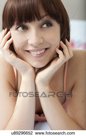 Close up of young woman lying on bed View Large Photo Image Stock Image - Close up of young woman lying on bed. Fotosearch