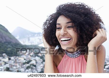 Stock Image - Close up portrait of happy young woman, Casa Alto Vidigal, Rio De Janeiro, Brazil. Fotosearch