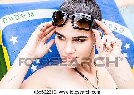 Close up portrait of young woman holding sunglasses View Large Photo Image Stock Image - Close up portrait of young woman holding sunglasses. Fotosearch