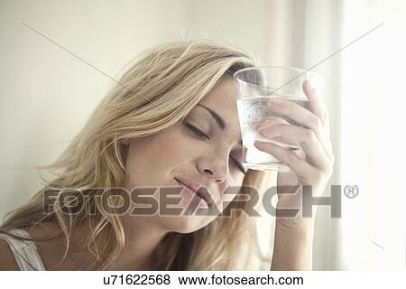Stock Photo - Close up portrait of young woman with glass of water. Fotosearch
