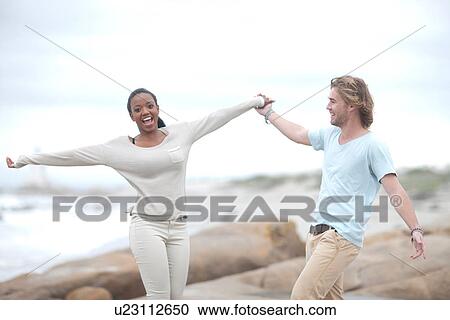 Stock Image - Couple dancing on beach. Fotosearch
