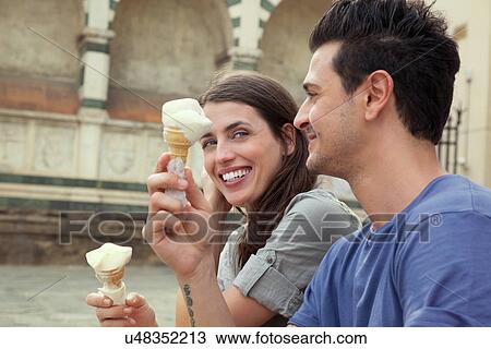 Stock Image - Couple eating ice creams, Santa Maria Novella square, Florence, Tuscany, Italy. Fotosearch