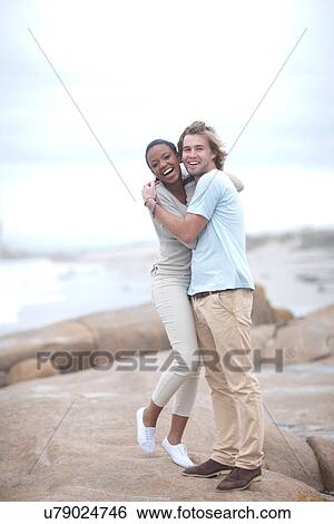 Stock Photograph - Couple hugging on beach. Fotosearch