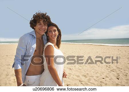 Stock Photograph - Couple posing for camera on beach. Fotosearch