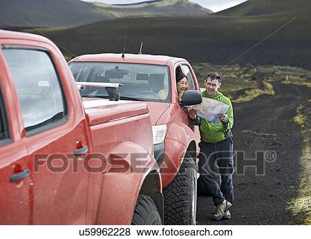 Stock Photo - Couple reading map by customised SUV, Hekla, Fjallabak, Iceland. Fotosearch