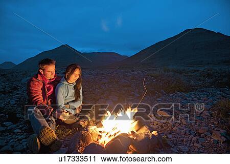 Couple sitting at campfire, Eyjafjordur, North Iceland View Large Photo Image Stock Image - Couple sitting at campfire, Eyjafjordur, North Iceland. Fotosearch
