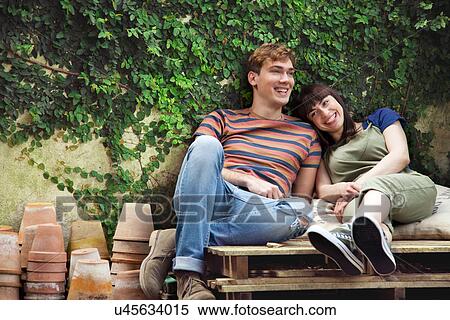 Couple sitting on wooden palettes with plant pots View Large Photo Image Stock Photography - Couple sitting on wooden palettes with plant pots. Fotosearch