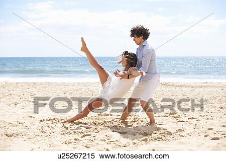 Stock Photography - Couple tangoing on beach. Fotosearch