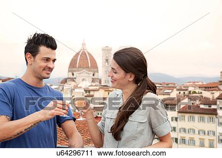 Stock Image - Couple toasting champagne, Florence Cathedral in background, Florence, Tuscany, Italy. Fotosearch