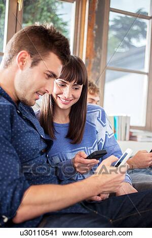 Stock Image - Couple using smartphones. Fotosearch