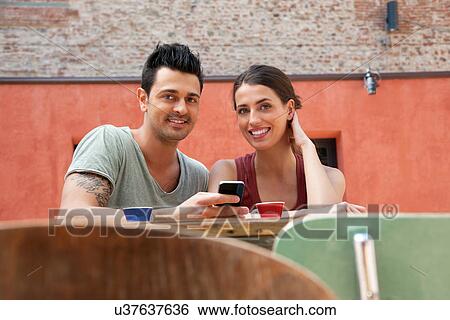 Couple with smartphone outside cafe, Florence, Tuscany, Italy View Large Photo Image Stock Photograph - Couple with smartphone outside cafe, Florence, Tuscany, Italy. Fotosearch
