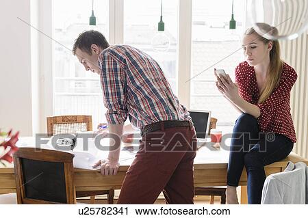 Stock Image - Couple working at home. Fotosearch