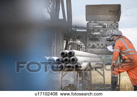 Stock Photo - Drilling rig worker inspecting machinery. Fotosearch