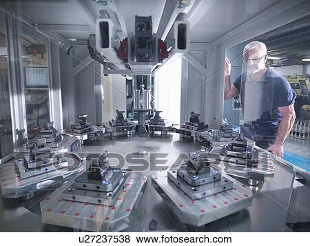 Engineer inspecting automatic lathe in factory View Large Photo Image Stock Photo - Engineer inspecting automatic lathe in factory. Fotosearch