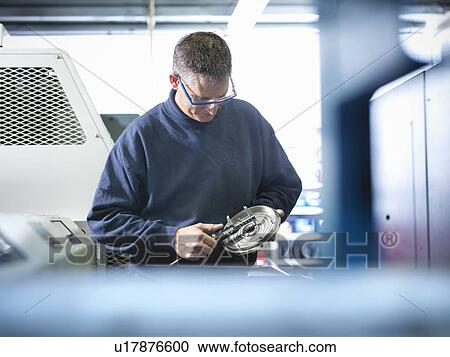 Engineer measuring metal part in factory View Large Photo Image Stock Image - Engineer measuring metal part in factory. Fotosearch