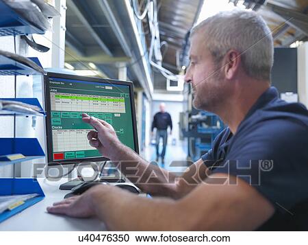 Engineer using touchscreen at computer workstation in factory View Large Photo Image Stock Image - Engineer using touchscreen at computer workstation in factory. Fotosearch
