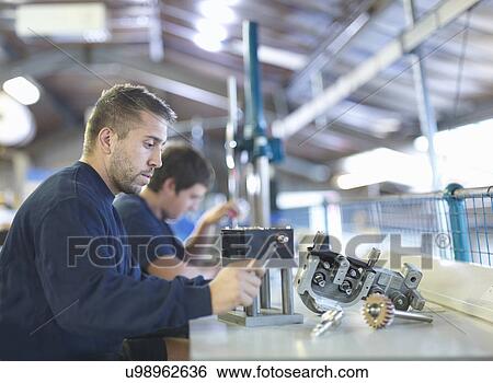 Engineer working on production line in factory View Large Photo Image Stock Photograph - Engineer working on production line in factory. Fotosearch