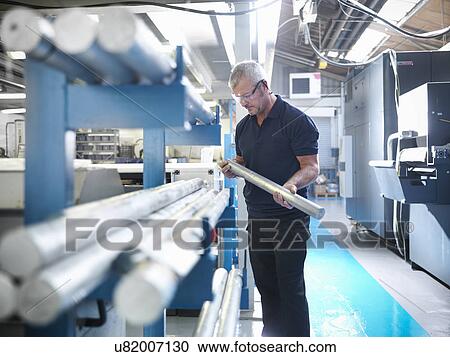 Stock Image - Engineer working with aluminium in factory. Fotosearch