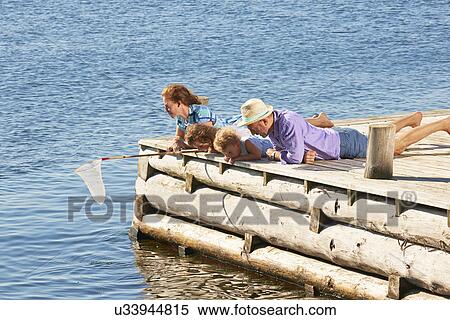 Stock Photography - Family fishing on pier, Utvalnas, Gavle, Sweden. Fotosearch