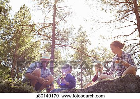 Family having picnic sitting on rocks View Large Photo Image Stock Image - Family having picnic sitting on rocks. Fotosearch