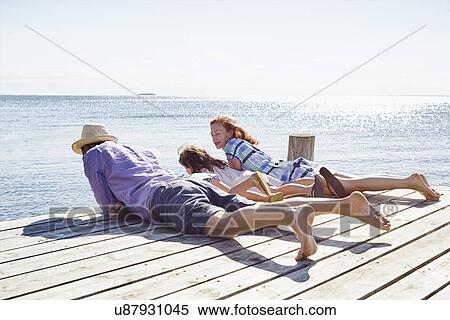 Stock Photography - Family lying on pier, Utvalnas, Gavle, Sweden. Fotosearch