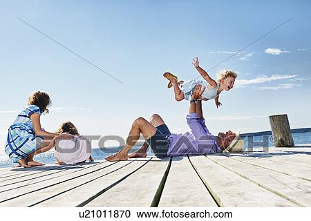 Stock Image - Family playing on jetty, Utvalnas, Gavle, Sweden. Fotosearch