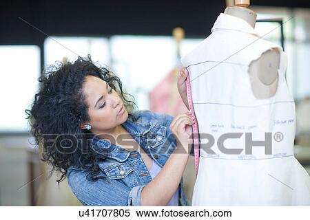 Stock Photography - Fashion design student measuring in class. Fotosearch