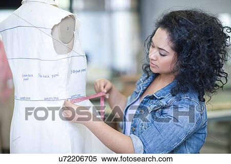 Stock Photography - Fashion design student measuring in class. Fotosearch