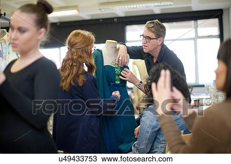 Stock Image - Fashion design teacher and students in class. Fotosearch