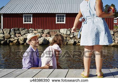 Stock Image - Father and two girls on pier, Utvalnas, Gavle, Sweden. Fotosearch