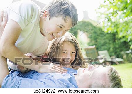 Father with son and daughter playing in garden View Large Photo Image Stock Image - Father with son and daughter playing in garden. Fotosearch